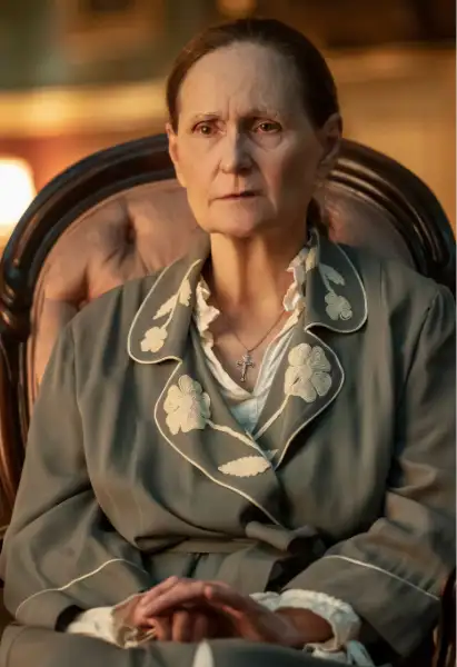 Beth Grant als Carlotta Mayfair in Mayfair Witches. Sie sitzt in einem bademantel auf einem Sessel.