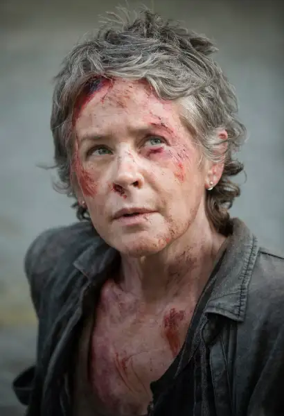 Melissa McBride als Carol Peletier, ihr Gesicht ist Blutverschmiert.
