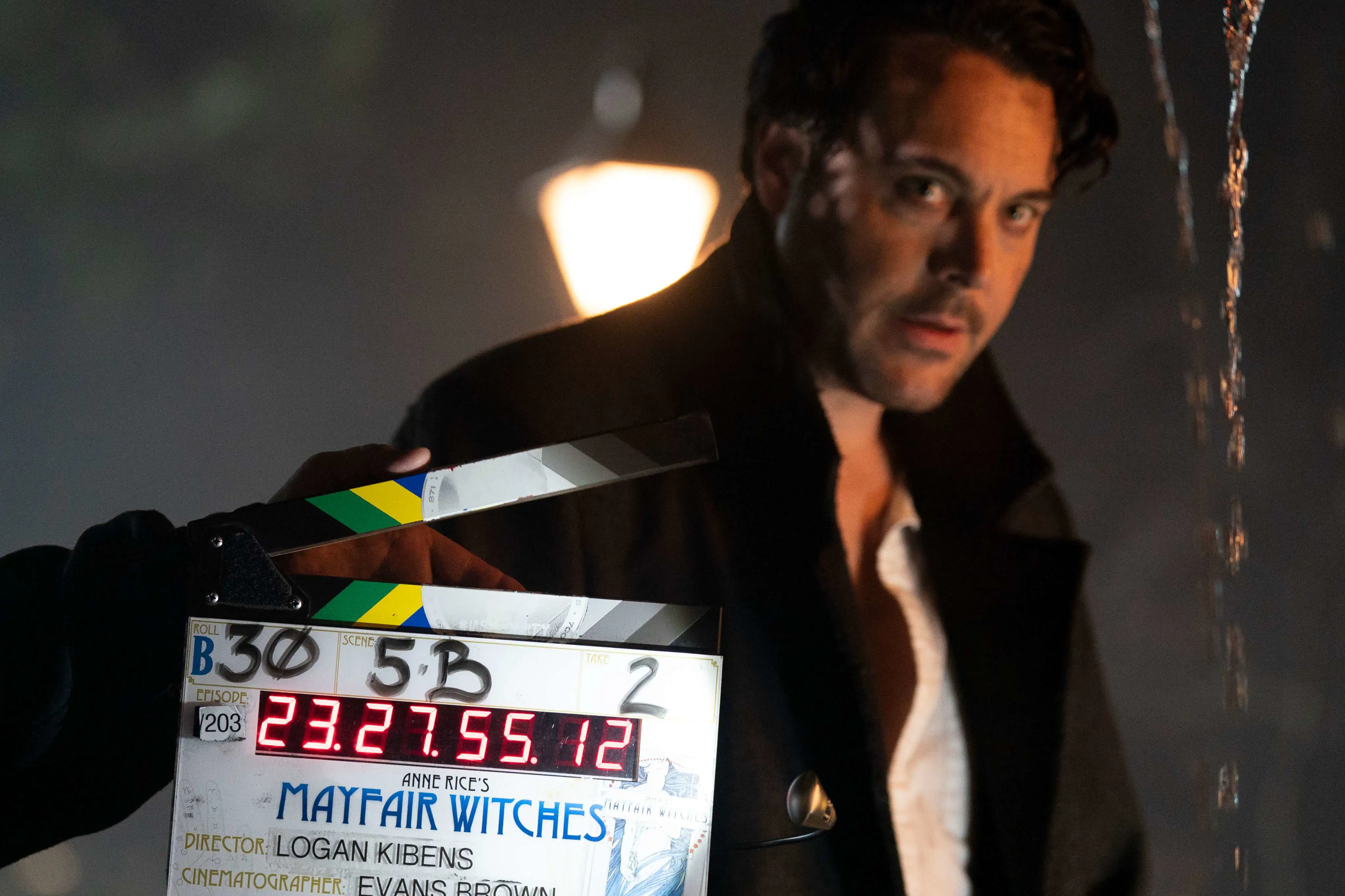 BTS Foto Mayfair Witches: Schauspieler dreht eine Szene, die Filmklappe ist zu sehen.