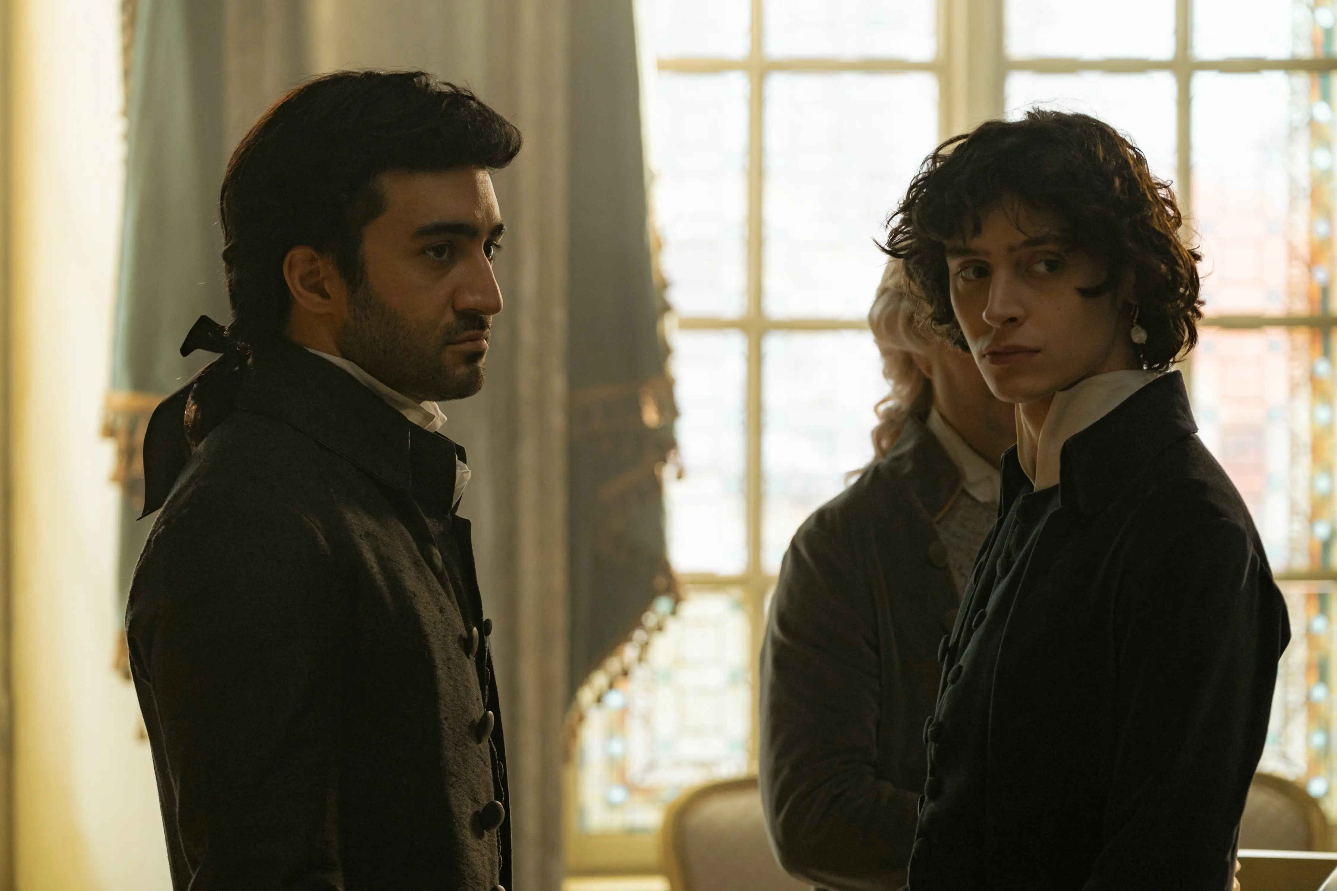 Eidin Jalali und Eren M. Güvenci als Salieri und Mozart. Beide tragen dunkle Mäntel, Jalali trägt eine dunkle Perücke.