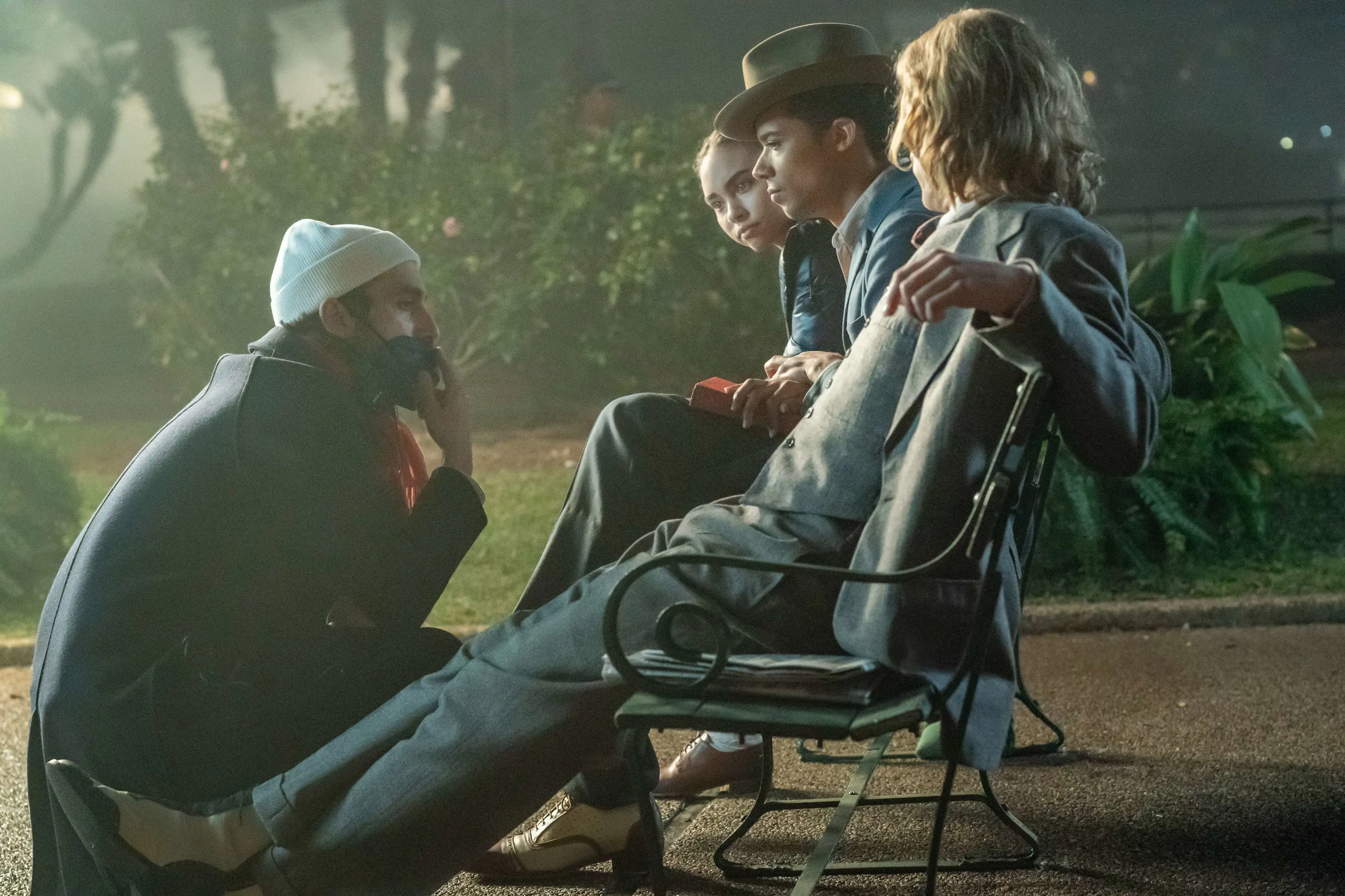 BTS Foto Interview with the Vampire. Brass Bailey, Jacob Anderson und Sam Reid sitzen auf einer Bank und sprechen mit einem Crewmitglied.