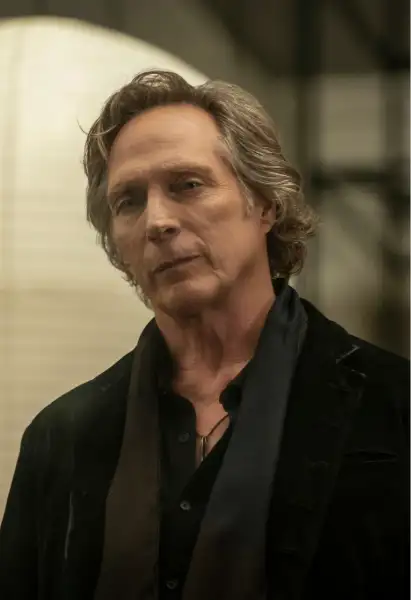 William Fichtner als Jasper in Talamasca. Er trägt eine schwarze Jacke über einem schwarzen Hemd, um seinen Hals ist ein Schal.