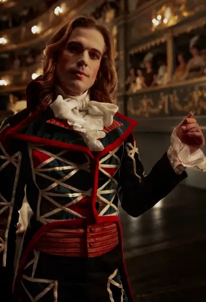 Sam Reid Lestat de Lioncourt in Interview with the Vampire. Er trägt einen schwarzen, goldgestreiften Anzug.