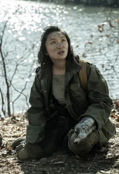 Poppy Liu als Amy in Tales of the Walking Dead. Sie trägt abgegtragene Kleidung, eine grüne Jacke und ein neiges T-Shirt. Ihre Hand ist ein Stumpf den sie mit einer Waffe aus Metall ausgestattet hat.