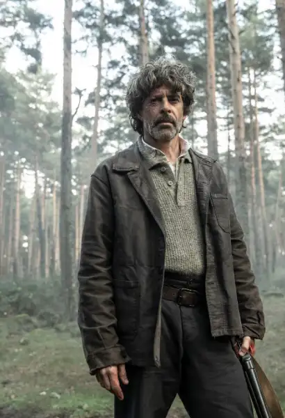 Eduardo Noriega als Antonio in The Walking Dead: Dead City. Er tägt eine schwarze Jacke und einen grauen Pullover. Seine Hose ist dunkel, in seiner linken Hand hält er einen Gürtel.
