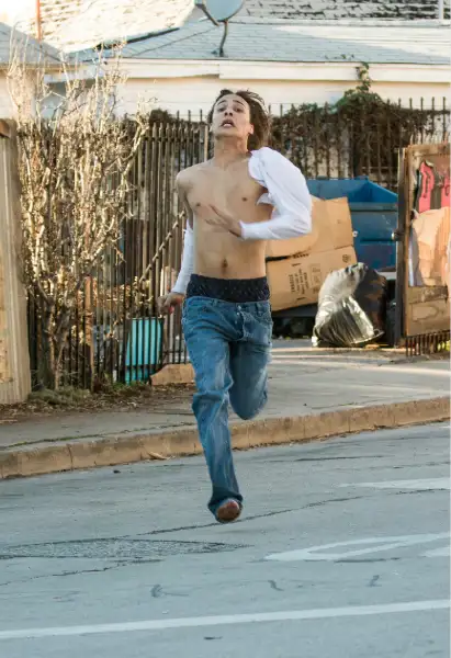 Frank Dillane als Nick Clark in Fear the Walking Dead. Er läuft vor etwas was wir nicht sehen können weg.